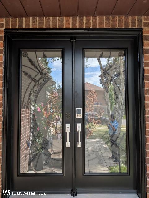 Double exterior doors for sale. Front entry steel insulated. Painted black. Full wrought iron glass inserts. Forest King Lions iron glass design. Antique brass bronze accents
